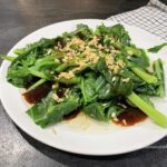 каи лан (китайская брокколи) в соусе с чесноком и устричным соусом на тарелке