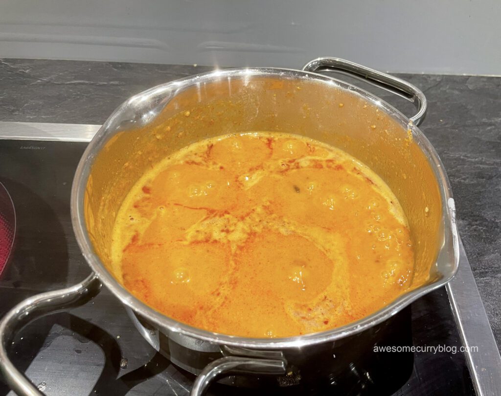 curry paste is cooking in a small pot for satay
