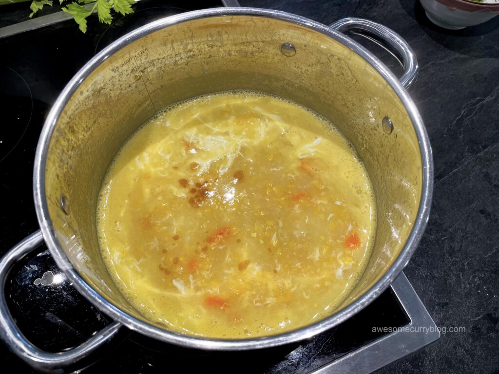 медленно и поочередно добавить куриную грудку и крахмал, после чего яйцо, все время помешивая