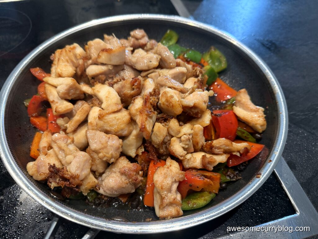 добавить курицу в сковороду, по желанию добавить воды, готовить под крышкой еще минуту